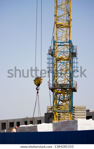 the worker and the crane operator unload the car\
with reinforced concrete walls for the future high-rise building.\
reportage shooting