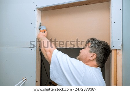 Worker cuts drywall with using multi tool