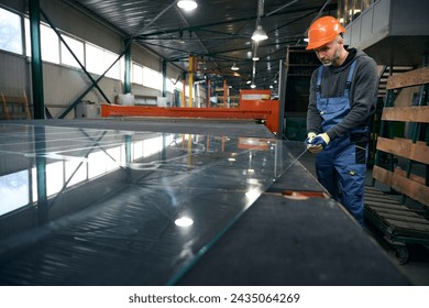 Worker cuts glass for a double-glazed window - Powered by Shutterstock