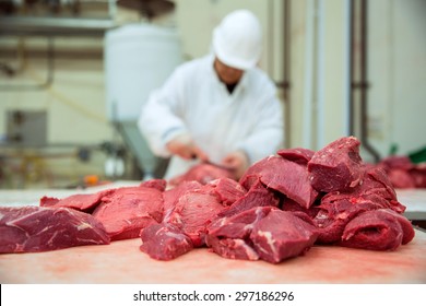 Worker cuts meat butcher handling cuts of prime choice cuts