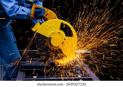 Worker cuts metal by electric circular saw. Fountain of grinding metal sparks. Industrial working with personnel protective equipment concept. - Powered by Shutterstock