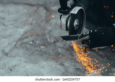 Worker Cuts A Metal Plate With Electric Circular Saw. Blurred Focus