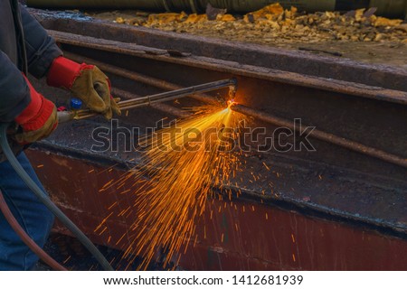 worker cuts scrap metal by thermal lance closeup