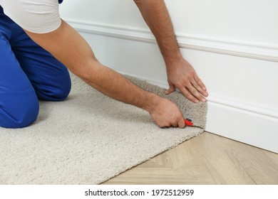 Worker with cutter knife installing new carpet indoors, closeup - Shutterstock ID 1972512959