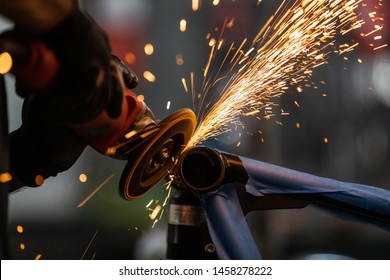 Worker cutting, grinding and polishing motorcycle metal part with sparks indoor workshop, close-up. - Shutterstock ID 1458278222