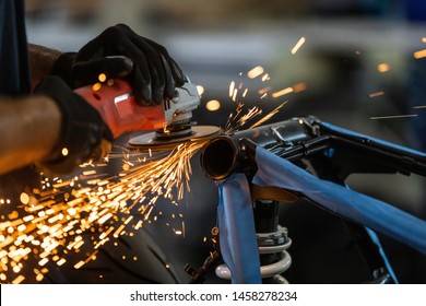Worker cutting, grinding and polishing motorcycle metal part with sparks indoor workshop, close-up. - Shutterstock ID 1458278234