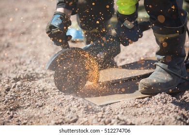 Worker Cutting Metal On The Ground By Angle Grinder Machine