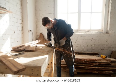 Worker Cutting Metal Plank With Angle Grinder In Workshop. Young Man Choosing Skilled Labor Trades As First Profession. Starting Own Small Business, Find Side Job In Furniture Manufacturing Concept