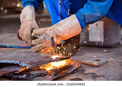 Worker cutting metal steel by Gas Cutting Torch. He cutting the iron plate in the workshop.