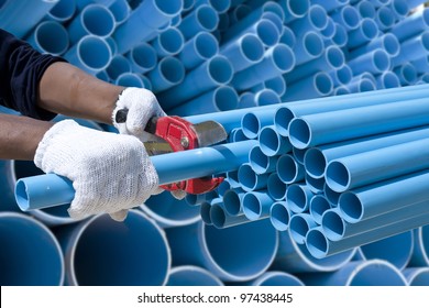 Worker Cutting Pvc Pipe In Construction Site