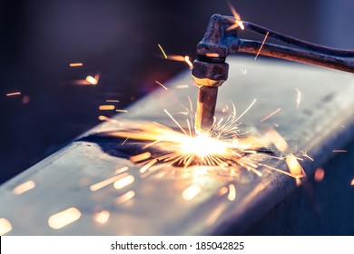 worker cutting steel pipe using metal torch and install roadside fence - Powered by Shutterstock