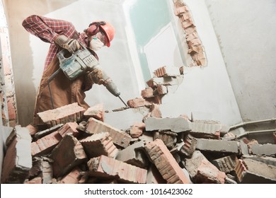 Worker With Demolition Hammer Breaking Interior Wall