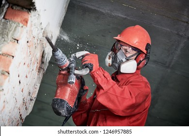 Worker With Demolition Hammer Breaking Interior Wall