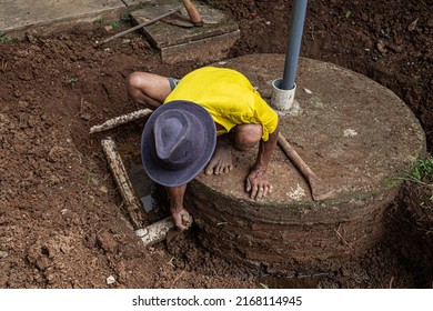 a worker digs the ground to repair a water catchment channeli