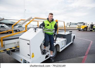 Worker Disembarking Luggage Conveyor Truck On Airport Runway