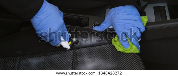 worker doing dry cleaning of the seat in the car,\
hands close up