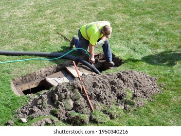 A Worker Doing Routine Maintenance Pumping Out A Home Septic Tank