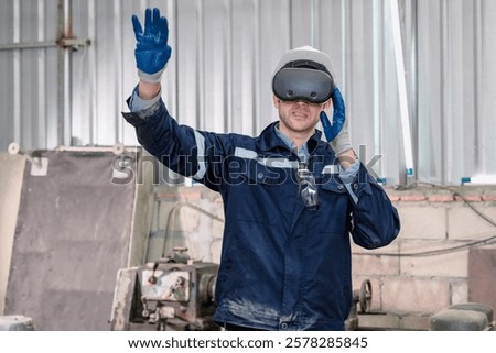 A worker donning a VR headset and gloves engages in a training session within an industrial facility. Robotics and equipment surround him, highlighting innovative technology applications.