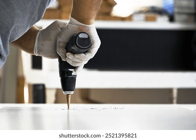 Worker drilling a hole with a drill
