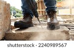 A worker was drilling rocks, and wearing safety shoes to protect his feet