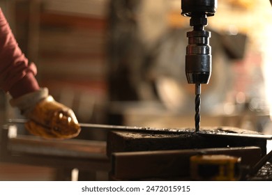 Worker drills iron with a bench drill. Metal Drill bit drills hole in steel billet on industrial machine. Metal processing industry. A metal workshop in Turkey - Powered by Shutterstock