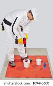 Worker With Electric Drill Mixer Mix Tile Grout On Bucket