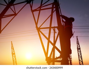 Worker At An Electric Substation With Sunset Background