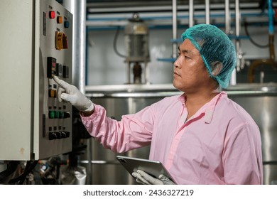 Worker employs tablet in beverage production while an engineer supervises soda water filling. Emphasizing quality control ensures top industry standards for bottle manufacturing. - Powered by Shutterstock