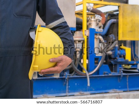 Worker engineer Man work in oil or gas refinery, turning on and off the pipeline valve torso and hand engineer yellow helmet for workers security construction worker .