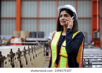 worker or engineer talking on smartphone and looking above in the factory