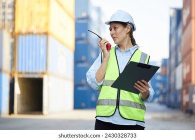 worker or engineer using walkie talkie and talking about work in containers warehouse storage