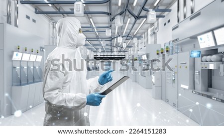 Worker or engineer wears protective suit or white coverall suit work in semiconductor manufacturing factory