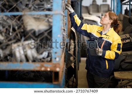 Worker examines metallic scrap inside a factory