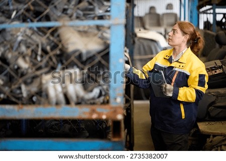 Worker examines metallic scrap inside a factory