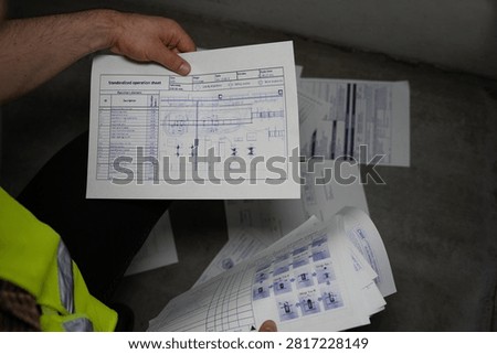Worker examining technical schematic in industrial setting
