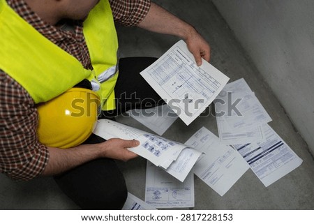 Worker examining technical schematic in industrial setting