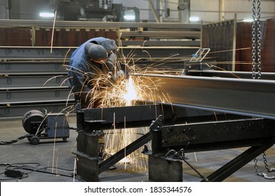 A Worker In A Factory Is Cleaning The Steel Structure Of An Angle Grinder In A Workshop. Sparks