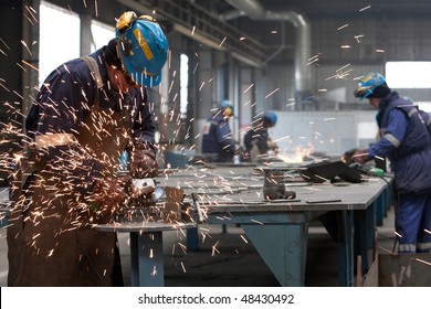 Worker In Factory Grinding Metal