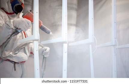 Worker At Factory Painting Metal Details With A Gun Of Powder Coating