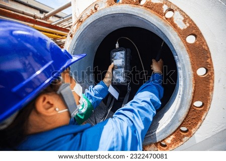 Worker female hand holding gas detector inspection safety gas testing at front manhole tank chemical to work inside confined space