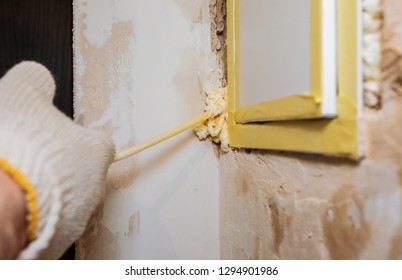 Worker Is Filling Spray Foam Near Electrical Panel. Maintenance Repair Works Renovation In The Flat. Restoration Indoors.