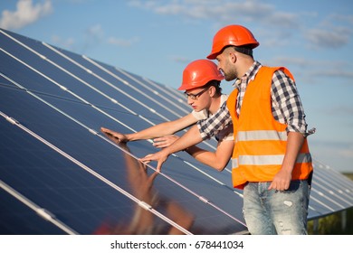 Worker And Foreman Maintaining Solar Energy Panel. Technicians Checking Equipment For Solar Energy Station.