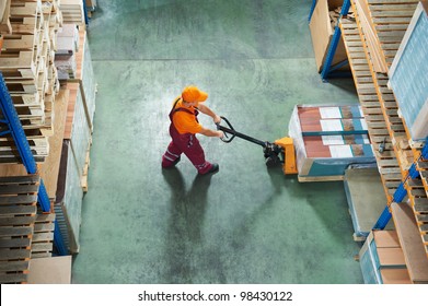 worker with fork pallet truck stacker in warehouse loading furniture panels - Powered by Shutterstock