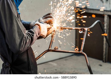 Worker In Furniture Factory Grinding Metal