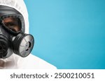 Worker in gas mask on light blue background, closeup. Space for text