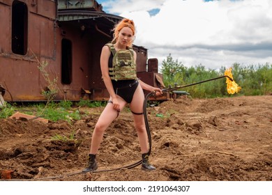 A Worker Girl In A Bulletproof Vest And A Black Bodysuit Holds A Thermal Lance. Hot Woman In Sparks With Flames. The Concept Of Feminism. Man Tools In Female Hands.