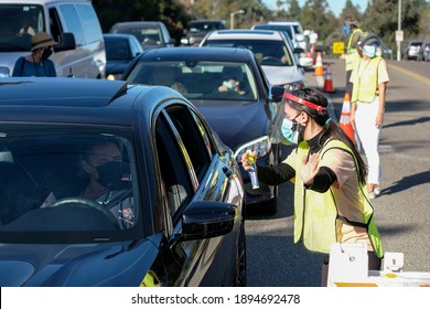 A Worker Gives Directions As Motorists Wait In Lines To Get The Coronavirus (COVID-19) Vaccine In A Parking Lot At Dodger Stadium, Friday, Jan. 15, 2021, In Los Angeles. 