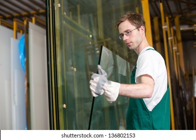 Worker in glazier's workshop  warehouse  storage handling glass
