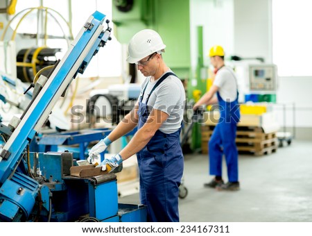 worker with goggles and helmet on the machine