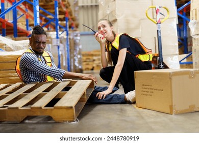 Worker got an accident while working inside the warehouse and his or her colleague quickly running to assist and call for emergency support. Warehouse worker have an accident during working.